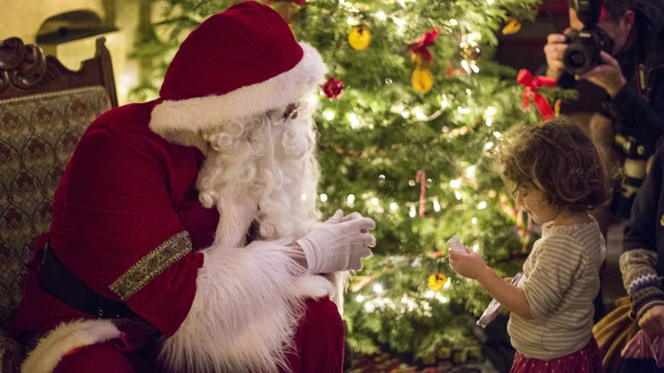 A small child accepts a gift from Father Christmas